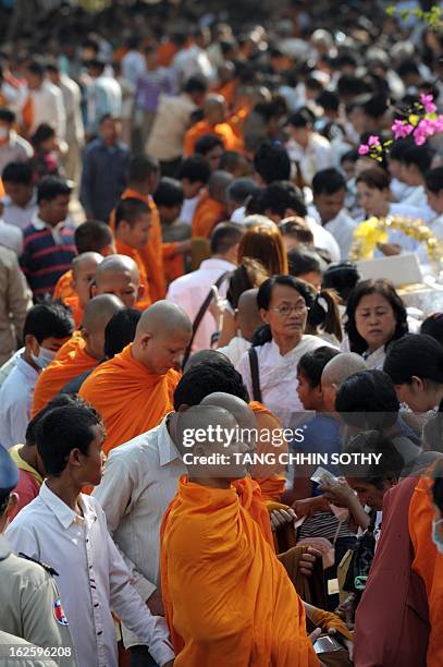 Cambodian people offer food to Buddhist monks during the Meak Bochea Buddhist celebration at the Oddong mountain in Kandal province, some 40...