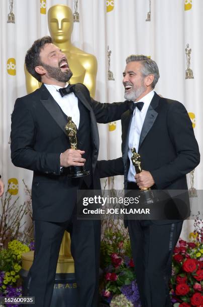 Ben Affleck and George Clooney celebrate in the press room after winning the trophy for Best Picture for "Argo" during the 85th Annual Academy Awards...