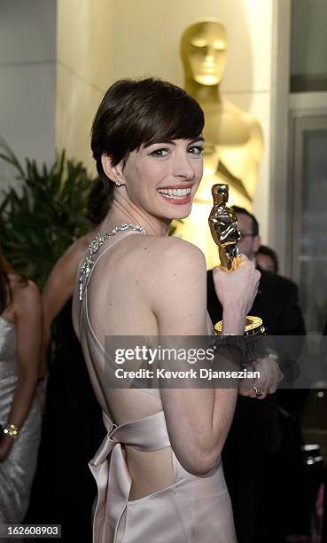 Actress Anne Hathaway holds her trophy for Best Supporting Actress for her performance in 'Les Misérables ' as she attends the Oscars Governors Ball...