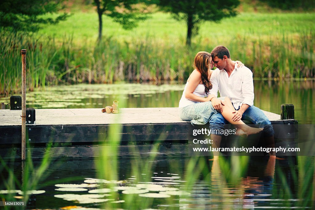 Boy and girl on the dock f a pond
