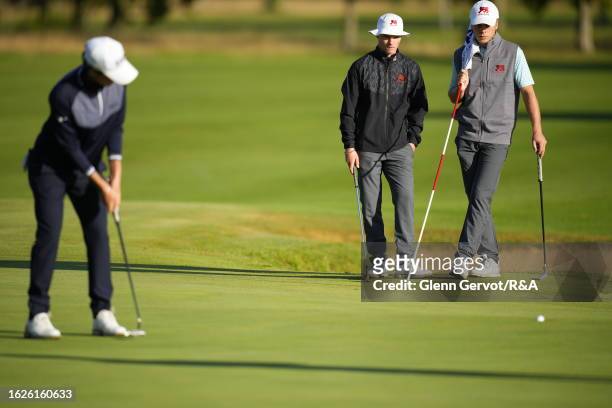 Team Great Britain and Ireland players Hugh Adams and Monty Holcombe looks at Continent of Europe player Lev Grinberg putting for a birdie on Day Two...
