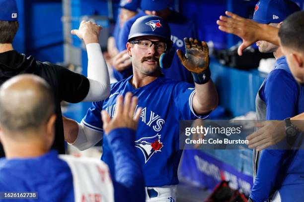 Davis Schneider of the Toronto Blue Jays celebrates as he scores a run off a Matt Chapman single in the fourth inning of their MLB game against the...