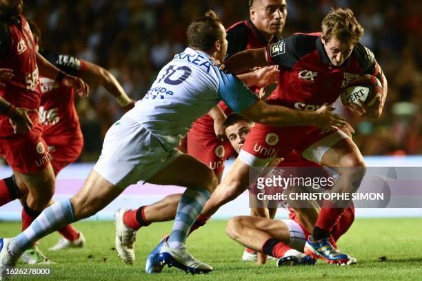 Toulon's French scrum-half Baptiste Serin is tackled by Bayonne's French fly-half Camille Lopez during the French Top 14 rugby union match between...