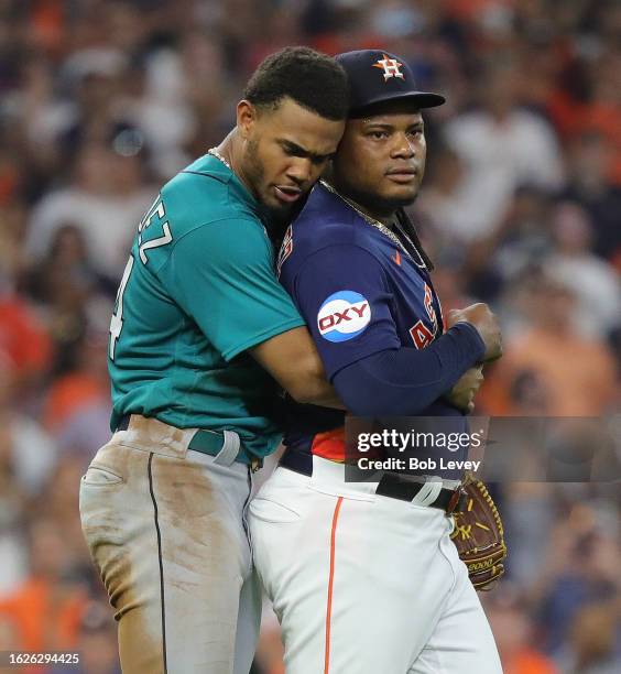 Framber Valdez of the Houston Astros is restrained by Julio Rodriguez of the Seattle Mariners after the both benches cleared after Valdez hit Jose...