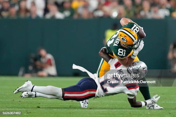 Josiah Deguara of the Green Bay Packers is tackled by Jalen Mills of the New England Patriots in the second quarter during a preseason game at...