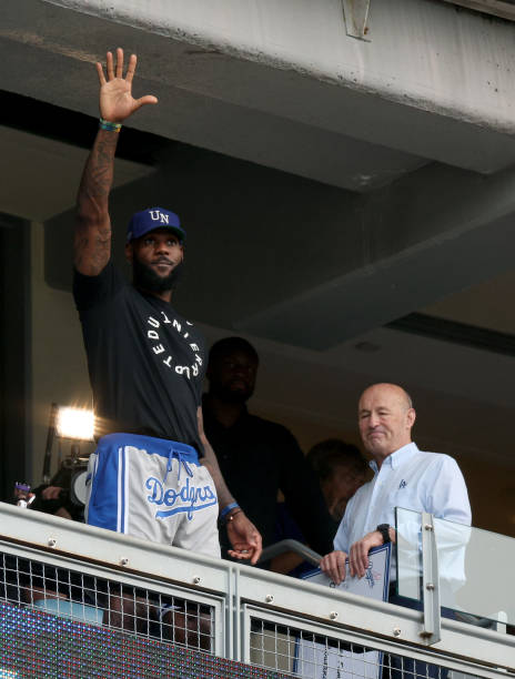 LeBron James of the Los Angeles Lakers waves to the crowd in front of President and CEO of the Los Angeles Dodgers Stan Kasten, during the game...