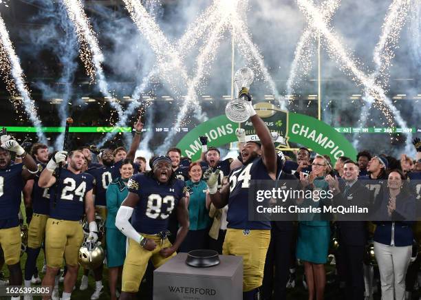 Notre Dame players celebrate with the Aer Lingus trophy following the Aer Lingus College Football Classic game between Notre Dame and Navy at Aviva...