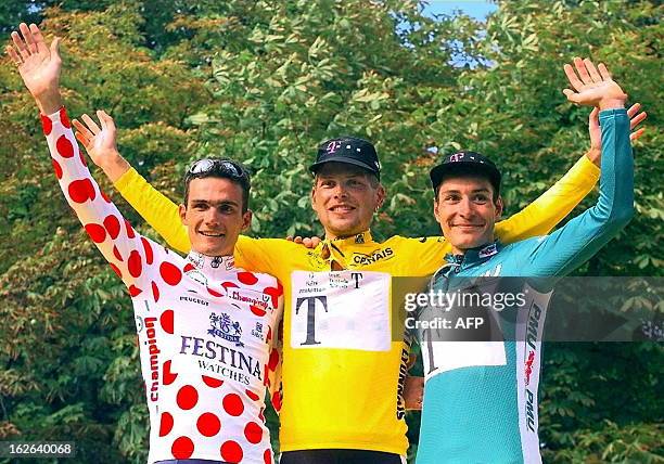 The 84th Tour de France winner German Jan Ullrich poses surrounded by his teammate and compatriot the green jersey Erik Zabel and the polka-dot...