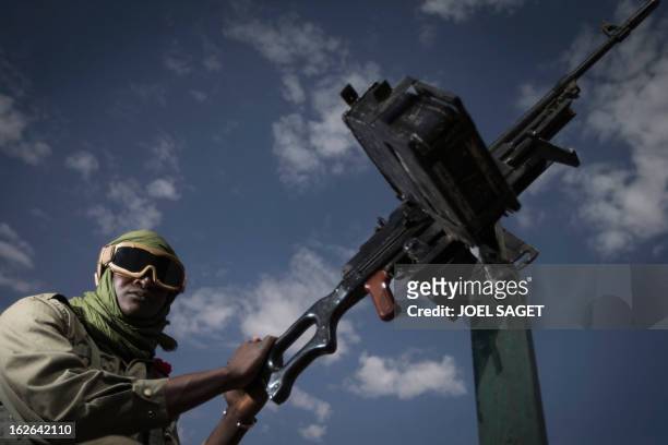 Malian army gunner Modibo Tangara, aged 22, stands beside a gun machine on February 25, 2013 in Gao, some 1,200 kilometres north of Bamako. After...