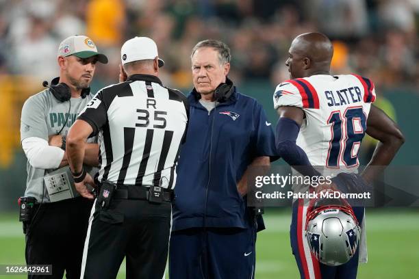 Referee John Hussey talks with head coach Matt LaFleur of the Green Bay Packers and head coach Bill Belichick of the New England Patriots before the...