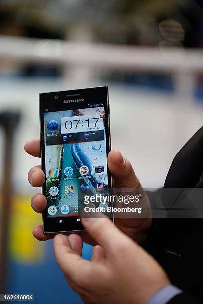 An employee displays a Lenovo K900 smartphone for a photograph at the Mobile World Congress in Barcelona, Spain, on Monday, Feb. 25, 2013. The Mobile...