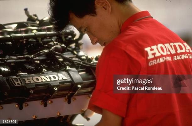 Japanese engine technician works on a Honda RA109E V10 engine in the Honda Marlboro McLaren pit garage during practice for the German Grand Prix on...