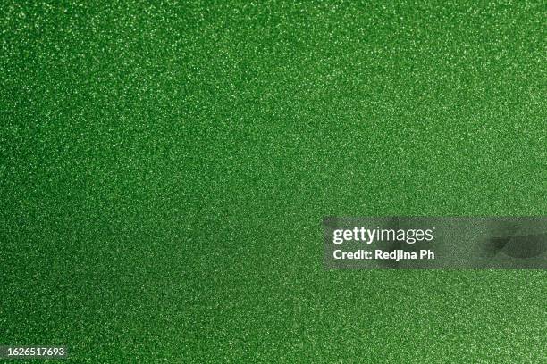 green shiny background with sparkling particles, a texture. a new year's and christmas festive backdrop. - fokus auf den hintergrund stock-fotos und bilder