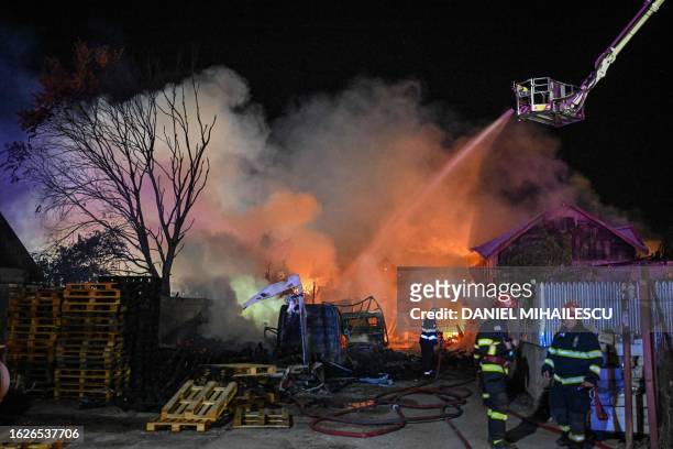 Romanian firemen attempt to estinguish fire during an intervention in Crevedia village, Romania August 27, 2023. One person died and 46 were injured...