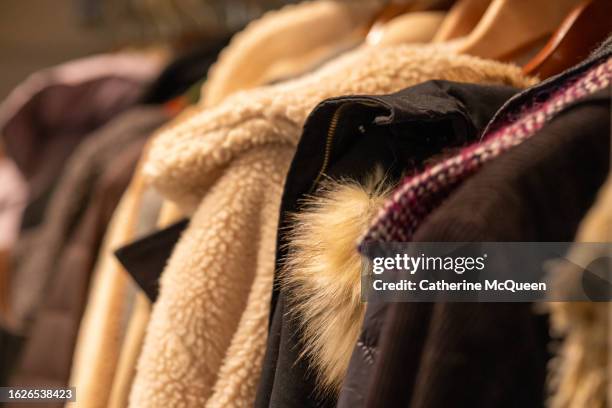 row of coats (some vintage) hanging in coat closet in residential home - belongings 個照片及圖片檔
