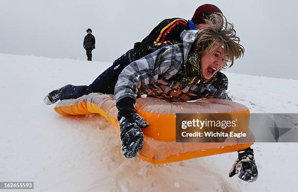 Simon Mourning, front, and Chance Cain fly into the air as they sled down a hill near downtown Wichita, Kansas on Monday, February 25, 2013.