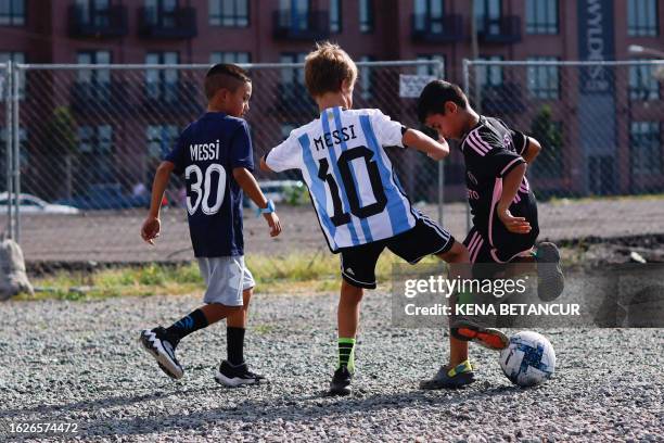 Boys play soccer as they wear Messi shirts outside the Red Bull arena ahead of the Major League Soccer 2023 match between Inter Miami and New York...