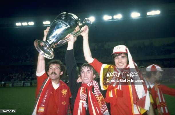 Graeme Souness Kenny Dalglish and Alan Hansen the three Scottish players for Liverpool hold up the European Cup after beating Real Madrid in the...