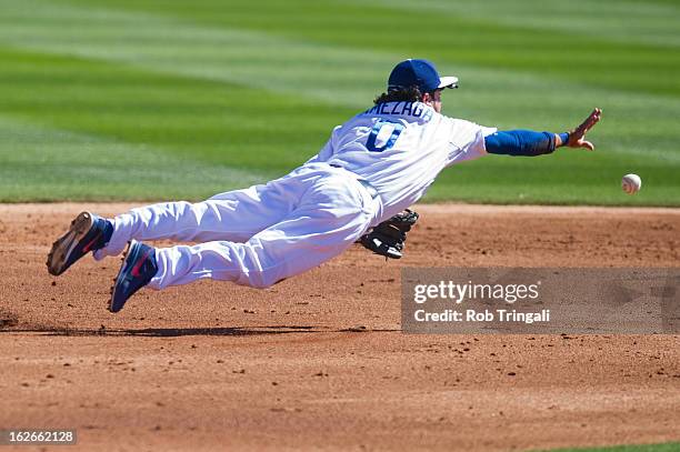 Alfredo Amezaga of the Los Angeles Dodgers leaps and tosses a ball in an attempt to get a force out at second base at Camelback Ranch on February 25,...