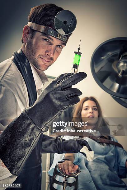 evil doctor trying out new serum on his female victim - restraining device bildbanksfoton och bilder