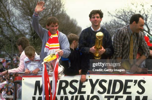 Kenny Dalglish, Jim Beglin and Bruce Grobbelaar all of Liverpool stand on the top of their homecoming bus with the FA Cup and the Canon League...