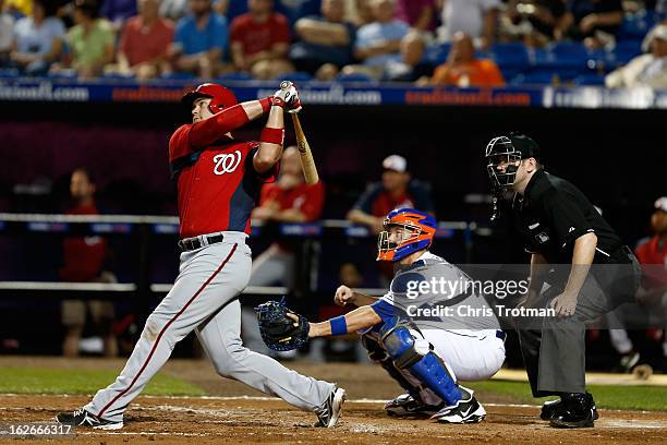 Chris Snyder of the Washington Nationals at swings as John Buck of the New York Mets lookns on at Tradition Field on February 25, 2013 in Port St....