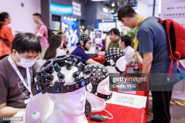 People visit brain-computer interface exhibition area during 2023 World Robot Conference at Beijing Etrong International Exhibition & Convention...