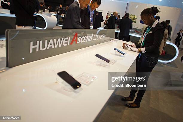 An employee cleans the screen of a Huawei Technologies Co. Ascend G526 smartphone at the Mobile World Congress in Barcelona, Spain, on Monday, Feb....