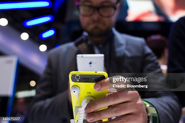 Visitor uses his mobile device to photograph a ZTE Corp. Grand S smartphone on display at the Mobile World Congress in Barcelona, Spain, on Monday,...