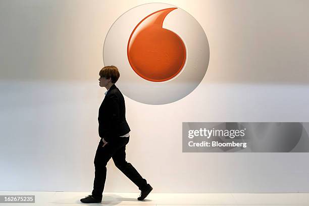 Visitor walks past a logo outside the Vodafone Group Plc pavilion at the Mobile World Congress in Barcelona, Spain, on Monday, Feb. 25, 2013. The...