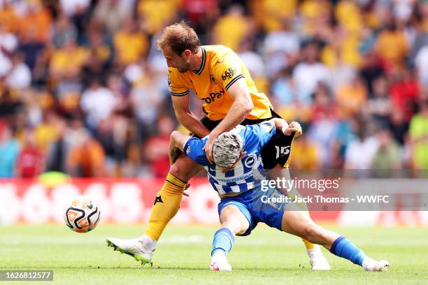 Craig Dawson of Wolverhampton Wanderers battles for possession against Julio Enciso of Brighton & Hove Albion during the Premier League match between...