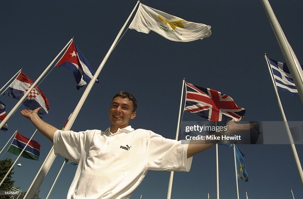 Portrait of Jonathon Edwards of Great Britain standing in front of national flags