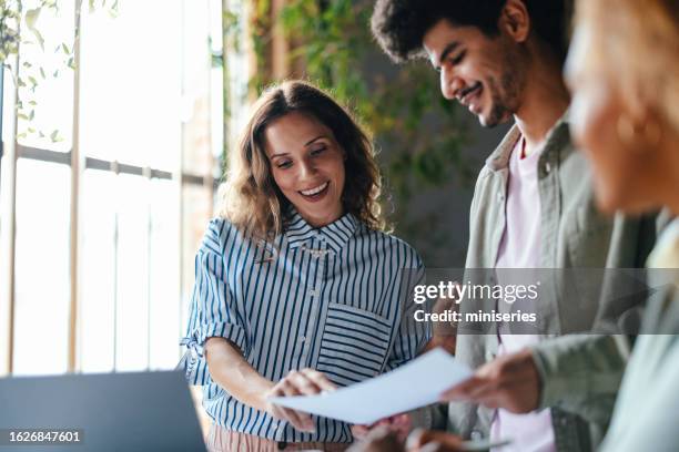 a happy beautiful blonde woman explaining some document to her colleague - coach bildbanksfoton och bilder