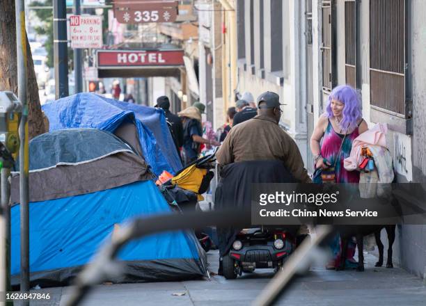 Homeless people and tents are seen on a sidewalk at the Tenderloin District on August 18, 2023 in San Francisco, California.