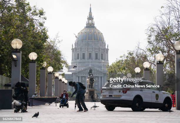 Homeless man walks by the San Francisco City Hall on August 19, 2023 in San Francisco, California.