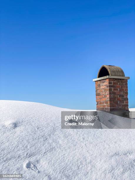 close-up of snow-covered roof and chimney against blue sky on a beautiful cold winter day. - period system der elements bildbanksfoton och bilder