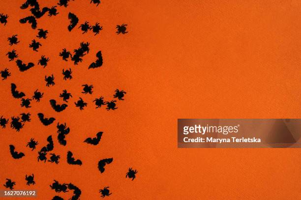 spiders and bats on an orange background. halloween. feast of all the dead. candy or death. - halloween text stock pictures, royalty-free photos & images