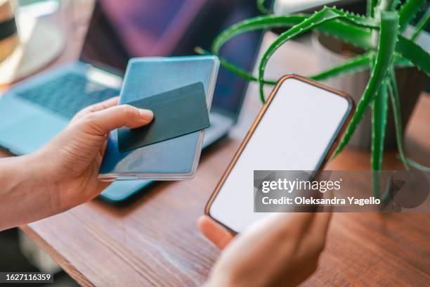 a woman holds passport, credit card and phone with white screen in her hands. - carte d'identité photos et images de collection