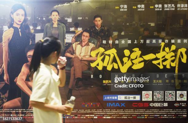 People walk past a poster of the popular movie "No More Bets" at a cinema in Hangzhou, east China's Zhejiang province, Aug. 27, 2023. August 27, 2023...