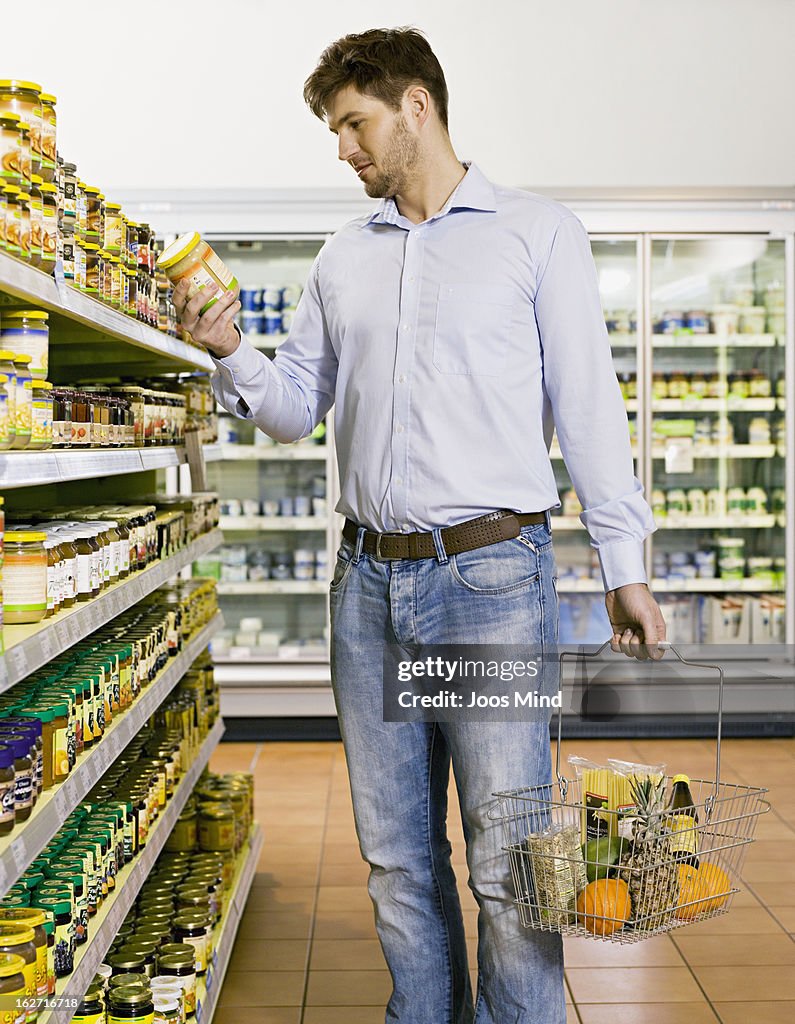 Man looking at product packaging in supermarket