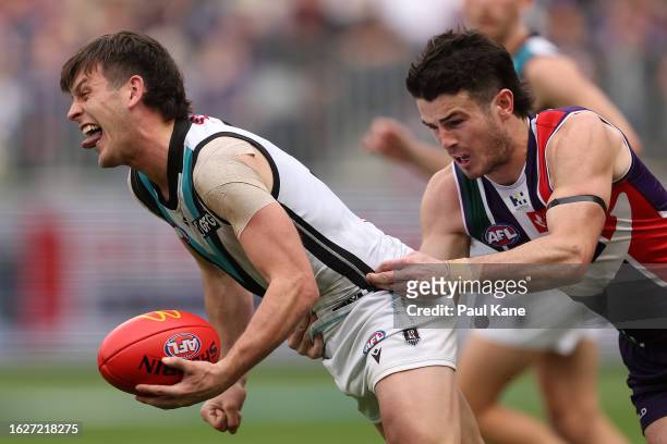 Zak Butters of the Power looks to handball against Andrew Brayshaw of the Dockers during the round 23 AFL match between Fremantle Dockers and Port...