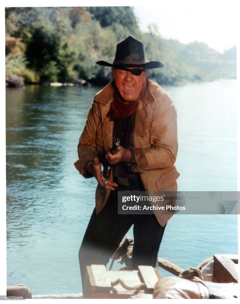 John Wayne aiming his gun in a scene from the film 'True Grit', 1969