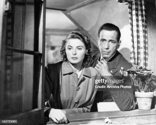 Ingrid Bergman and Humphrey Bogart looking out window in a scene from the film 'Casablanca', 1942.