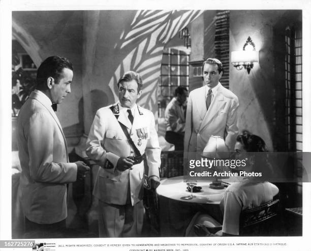 Humphrey Bogart addresses Claude Rains, Paul Henreid, and Ingrid Bergman in a scene from the film 'Casablanca', 1942.