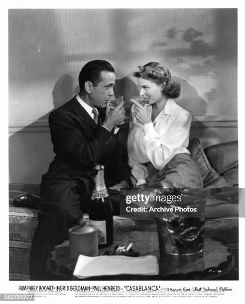 Humphrey Bogart and Ingrid Bergman sharing champagne in a scene from the film 'Casablanca', 1942.