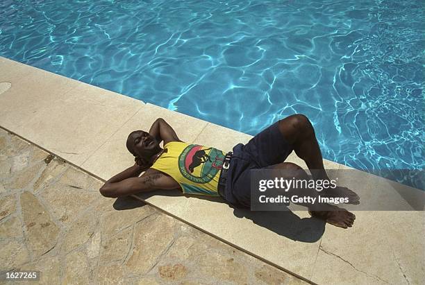 Roger Milla striker of the Cameroon team relaxes by a swimming pool during the World Cup in Italy. \ Mandatory Credit: Allsport UK /Allsport