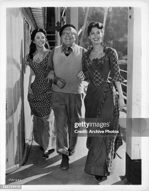 Kathryn Grayson, cameraman Charles Rosher, and Ava Gardner take a turn around the deck of the Cotton Blossom between scenes of the film 'Show Boat',...