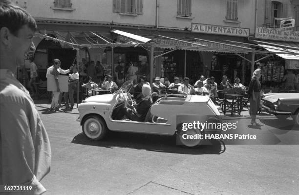 Holiday In Saint-Tropez. Les vacances à SAINT-TROPEZ, juillet 1961 : jeune femme au volant de sa Fiat 600 Jolly devant les terrasses des cafés du...