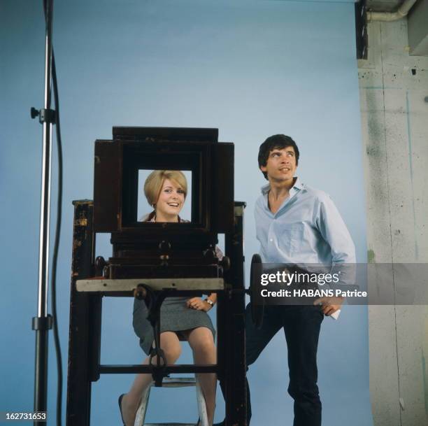 Rendezvous With Catherine Deneuve And David Bailey. Photo studio : attitude souriante de Catherine DENEUVE assise sur un tabouret, vue à travers une...