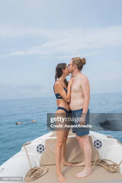 paar entspannt sich gemeinsam am bug des motorboots auf see - schiffsbug stock-fotos und bilder